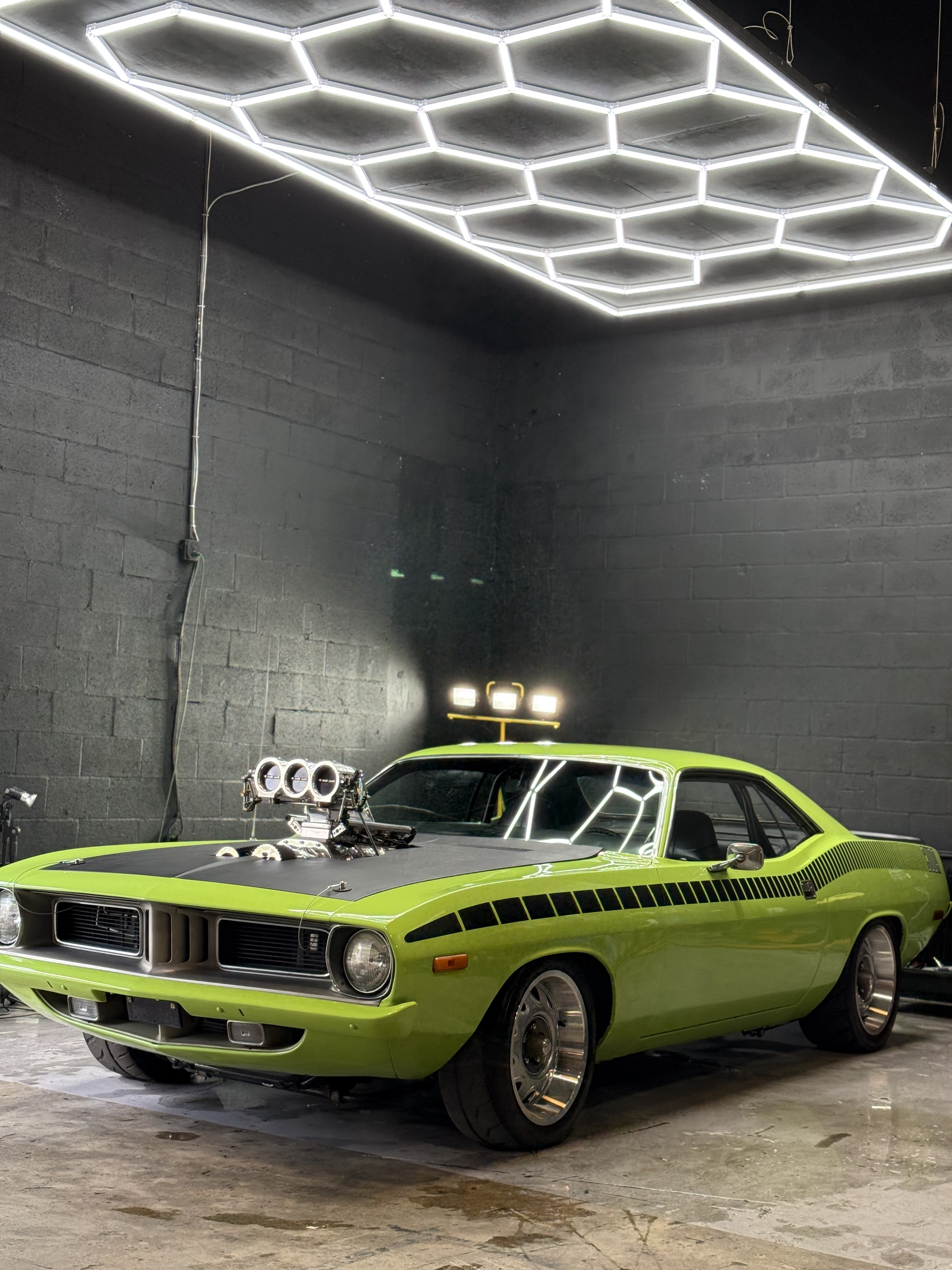 Green Plymouth Barracuda restomod under garage lighting